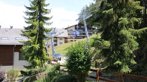 A residential area with houses, a ski lift, and a car parked on a driveway. - Mélèzes S 033 - SKI LIFT apartment 8 pers (Veysonnaz)