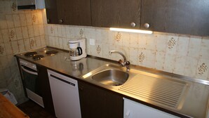 A kitchen with a dishwasher, stove, sink, and coffee maker. - Mélèzes S 033 - SKI LIFT apartment 8 pers (Veysonnaz)