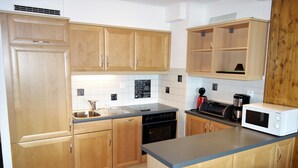A kitchen with wooden cabinets, a dishwasher, a microwave, and a coffee maker.