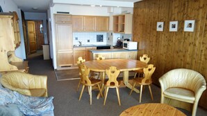 A compact living space with a kitchen, dining area, and a sofa.