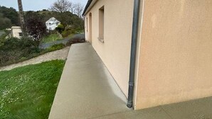 A building with a concrete pathway leading to a door, surrounded by greenery and a road. - Independent house for 6 in Barneville-Carteret with WiFi and bikes (Barneville-Carteret)