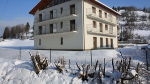 A multi-story building with balconies, surrounded by snow. - Beautiful modern villa with large suites in the middle of the mountains (Oščadnica )