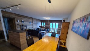 Een moderne keuken met houten kastjes, een eettafel en een bar.