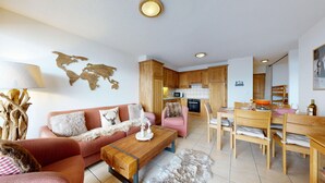 A cozy living room with a sofa, coffee table, and a world map on the wall. - Plein Ciel VA 032 - MOUNTAIN apartment 6 pers (Veysonnaz)