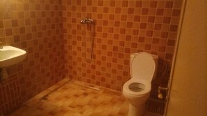 A small bathroom with a tiled floor, a sink, and a toilet. - private room with bathroom (Touama)