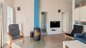 Una sala moderna con chimenea, televisor y zonas de estar.