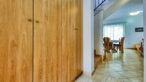 A wooden wardrobe in a hallway with a dining area visible in the background. - Pet friendly home in Buje (Buje)