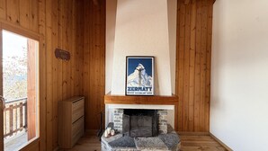 Un interno in legno con un camino, un poster e una porta di legno.