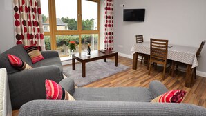 A living room with a sofa, a coffee table, and a dining table with chairs.