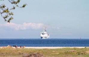 Un gran crucero en el océano con cielo despejado y algunas nubes al fondo.