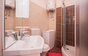 Ein Badezimmer mit Waschbecken, Toilette und Dusche.