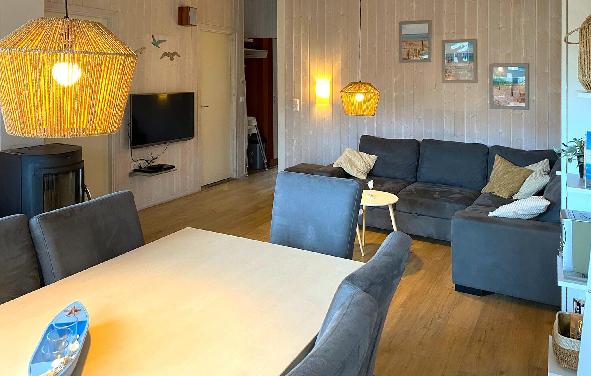 A modern living room with a sofa, a dining table, and a TV.