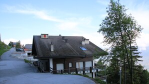 Un bâtiment doté d’un toit en pente, d’un petit porche et offrant une vue sur le paysage.