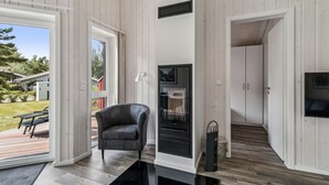 A modern living room with a black leather chair, a fireplace, and a TV mounted on the wall.