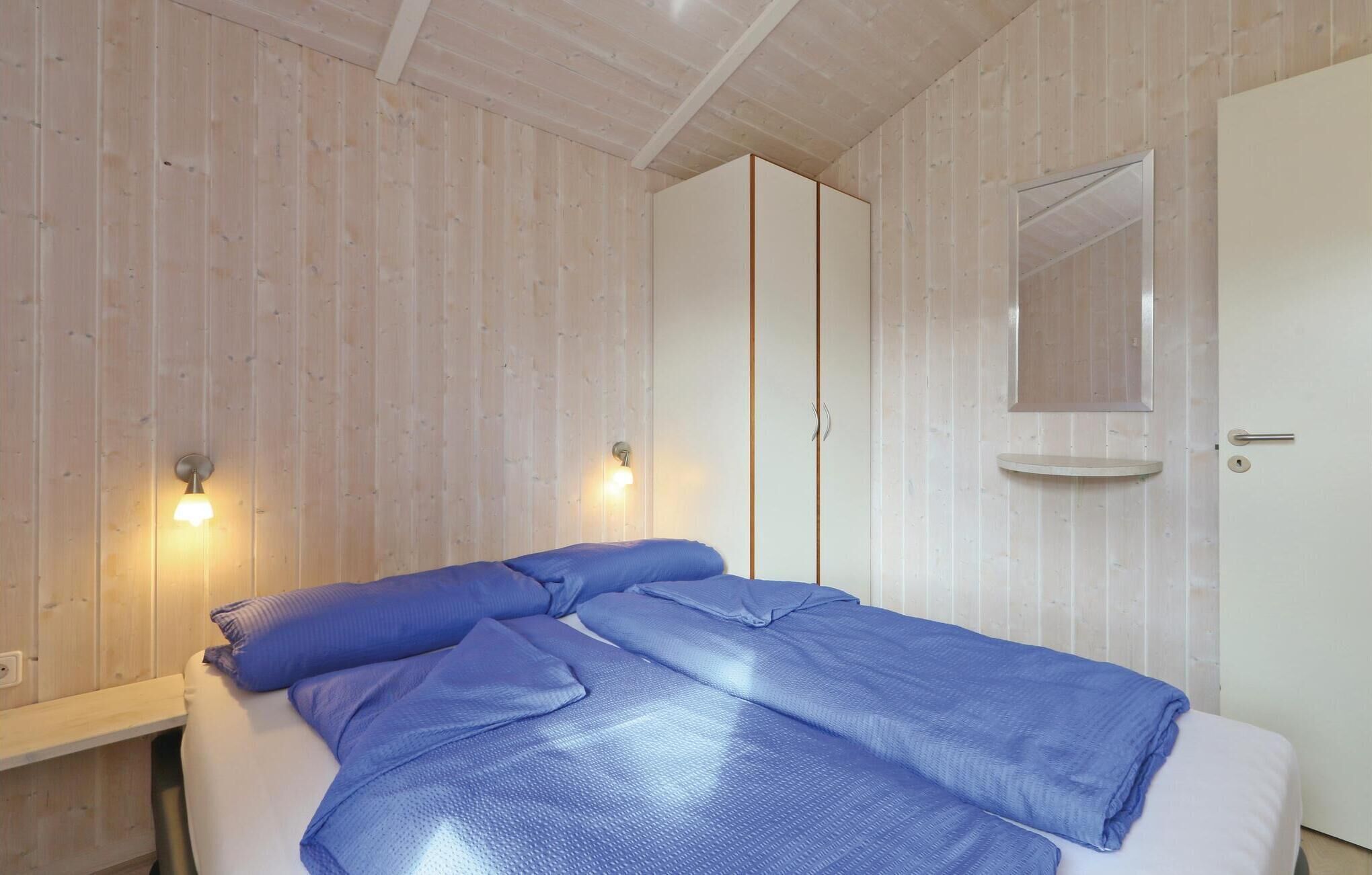 Une chambre à coucher avec un lit, une armoire et un miroir.