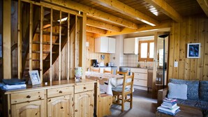 Ein Holzblockhaus-Interieur mit Essbereich, Küche und einer gemütlichen Sitzecke.