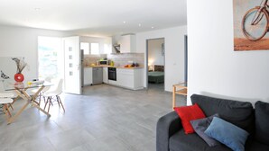 Un appartement moderne comprenant un coin repas, une cuisine et un salon.