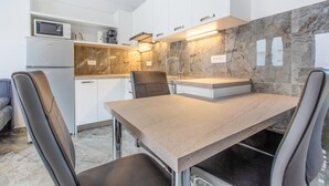 Een moderne keuken met een marmeren spatwand, roestvrijstalen apparatuur en een ingebouwde magnetron.