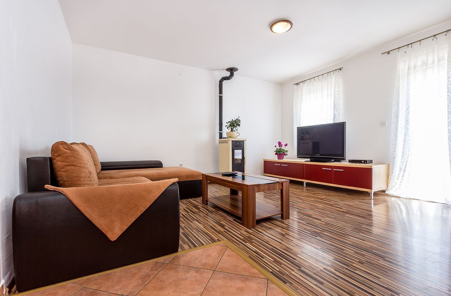 A modern living room with a sofa, a coffee table, a TV, and a cabinet.