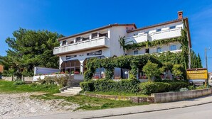 A two-story building with a sign reading "IL CASTELLO" and "SALATE-PASTA PIZZA GRILL-FISCH OPEN PEN OPEN." - Large apartment with air conditioning, WiFi (Premantura)