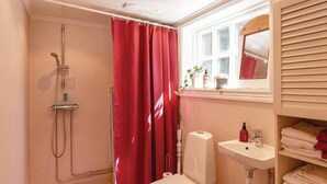 A bathroom with a shower, toilet, and sink.