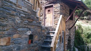 A stone building with a wooden staircase leading to a door. - The Balcony of Sotillo. Near Las Médulas (Sotillo de Cabrera)