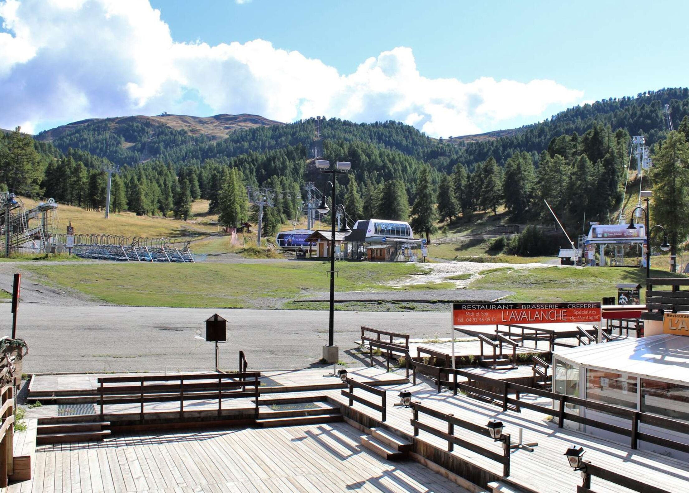 A wooden deck with benches and a sign for a restaurant named "L'avalanche".