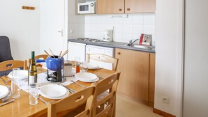 Kompakti keittiö, jossa on puukalusteet, mikroaaltouuni ja astianpesukone.