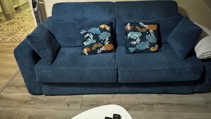 A blue sofa with patterned cushions, a white coffee table, and two remote controls on it. - Villa Marcaraïmon - between land and sea (Rivière-Pilote)