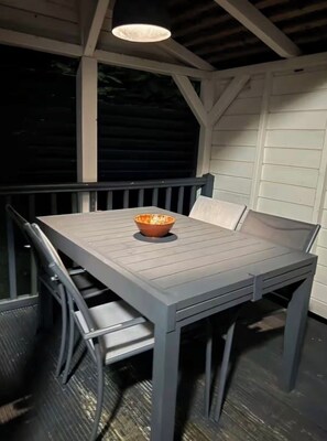 Un área de comedor al aire libre techada, con una mesa y sillas.
