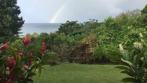 A lush garden with a variety of plants and a view of the ocean. - Villa Marcaraïmon - between land and sea (Rivière-Pilote)