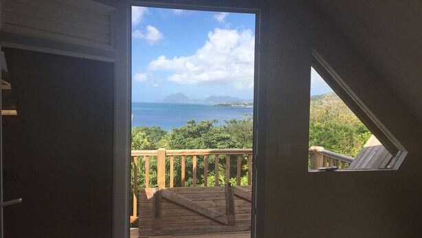 A room with a wooden deck and a view of the ocean. - Villa Marcaraïmon - between land and sea (Rivière-Pilote)