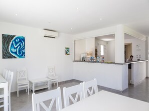 Ein Empfangsbereich mit Theke, Stühlen und einem Gemälde an der Wand.