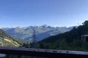 A mountainous landscape with a power line tower and a lake.