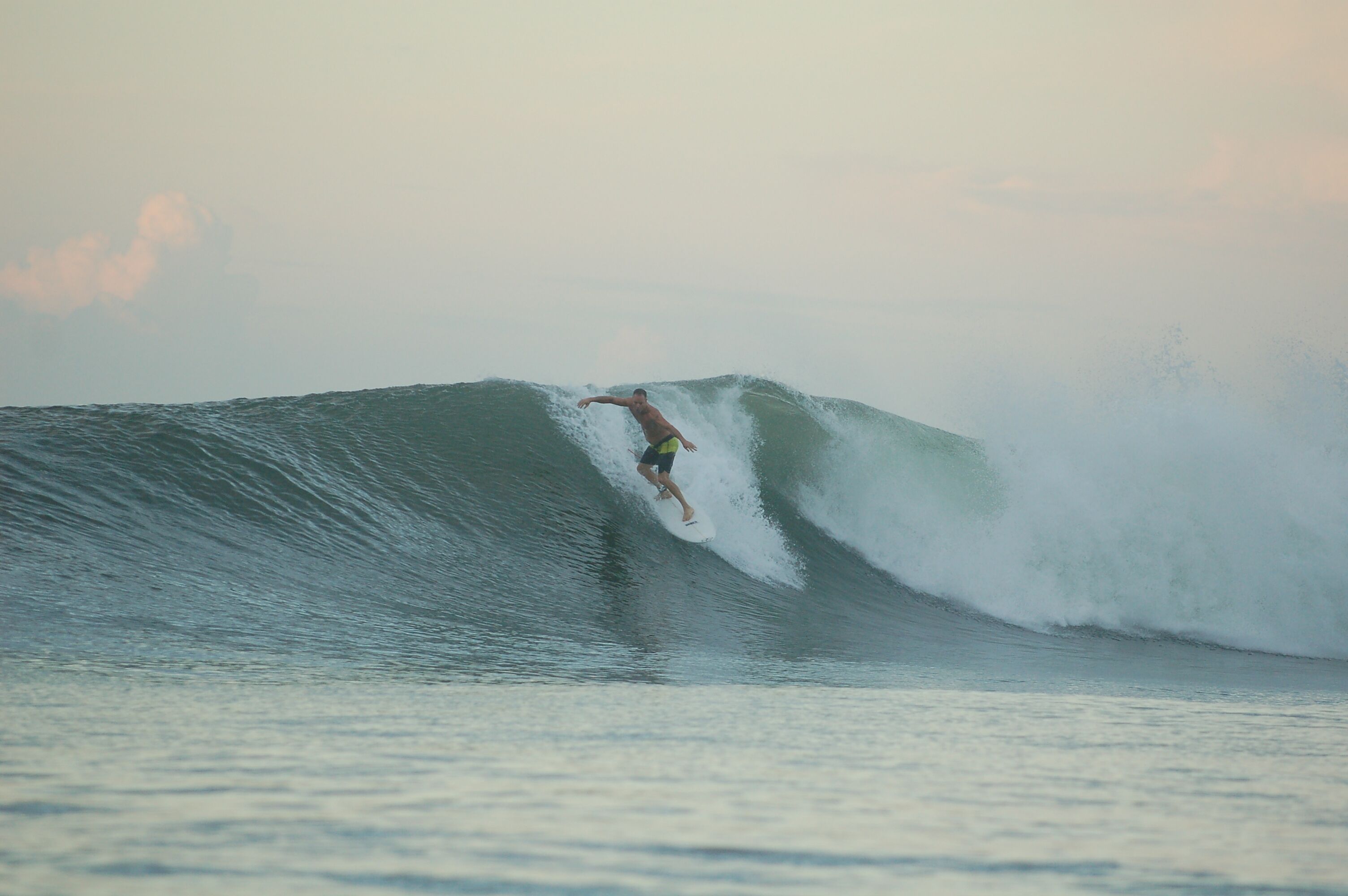 A surfer riding a large wave in the ocean.