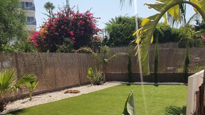 A well-maintained lawn with a variety of tropical plants and a wooden fence. - Protaras Villa Michelle 8 Near The Beach (Protaras)