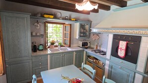 Una cocina con una mesa de comedor, un fregadero, una estufa y una ventana.