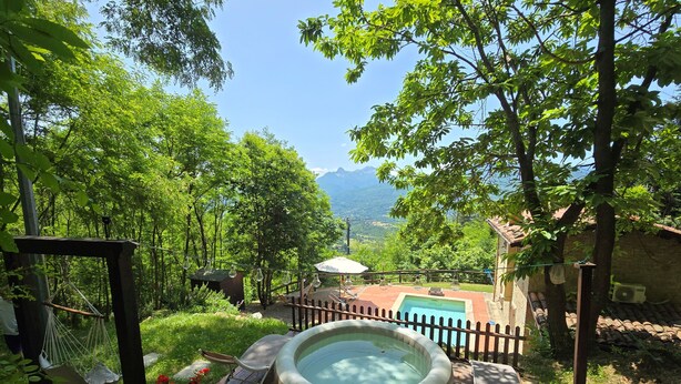 Un jacuzzi en una terraza de madera con vistas a las montañas.