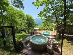 A hot tub on a wooden deck with a view of mountains. - Romantic Tuscany villa with private pool in stunning location, complete privacy. (Castiglione di Garfagnana)