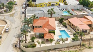 A residential area with multiple houses, a swimming pool, and a curved road. - PALM BEACH LUXURY VACATION  VILLA !!!!! (Palm beach)