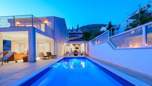 A modern pool area with a clear view of the pool, lounge chairs, and a covered seating area. - Spacious 5 bedroom Stone Villa with Private Pool and Sea view  (Mlini)