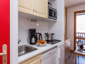 A compact kitchen with a microwave, coffee maker, and croissants on the counter. - Apartment in Valmeinier with Valley Views (Valmeinier)