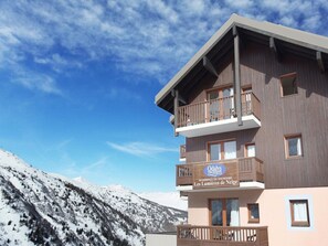 A multi-story hotel with balconies and a sign indicating it's a residence for tourism.