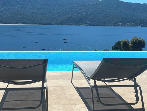 An infinity pool with a view of the sea and mountains.