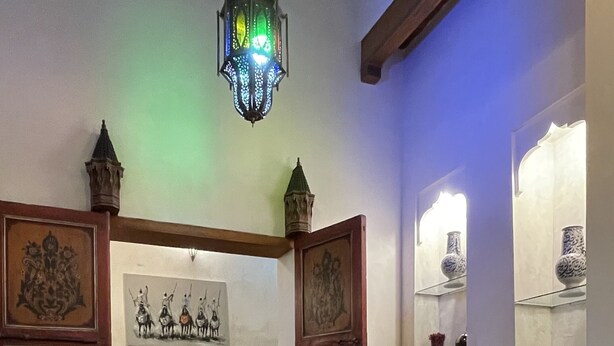 Una habitación con piso a cuadros, una mesa de comedor, un sofá y faroles decorativos.