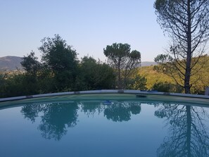 Une piscine offrant une vue dégagée sur les arbres et les collines environnantes.