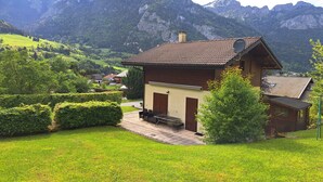 A chalet with a sloped roof, a small porch, and a view of a mountainous landscape. - Delightful Chalet, village location, garden, parking, views and WiFi (Le Biot)