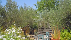 A garden with a wooden fence, potted plants, and outdoor furniture. - Apartment 80 m2 for 4 people, sea view, swimming pool, parking, washing machine (Kamilari)