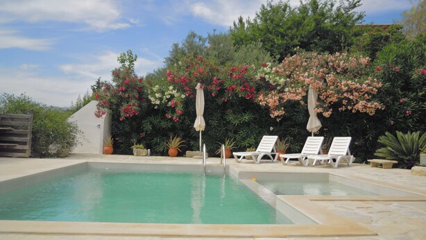 A swimming pool with two lounge chairs and a pergola with umbrellas. - Apartment 80 m2 for 4 people, sea view, swimming pool, parking, washing machine (Kamilari)