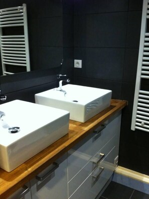 A modern bathroom with two white sinks, a wooden countertop, and a mirror above the sinks. - Apartment with large balcony, warm, completely renovated (Tignes)